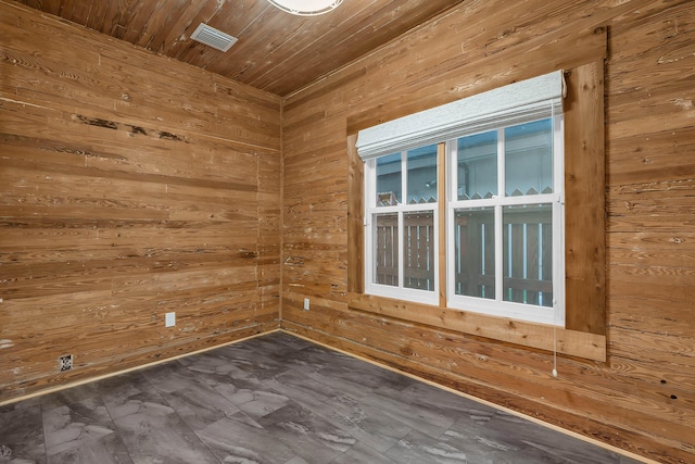 empty room with wood walls, wood ceiling, and visible vents