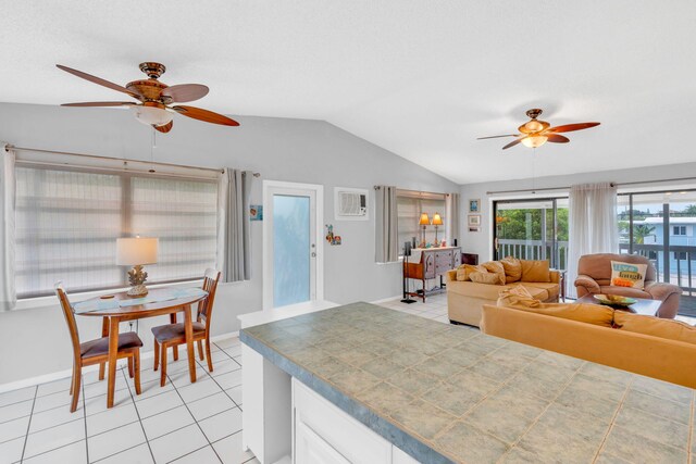 kitchen with lofted ceiling, ceiling fan, white cabinets, and light tile patterned flooring