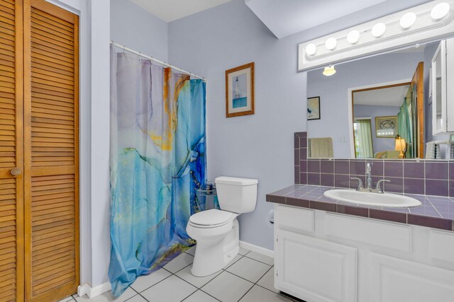 bathroom featuring a shower with shower curtain, tasteful backsplash, vanity, tile patterned floors, and toilet