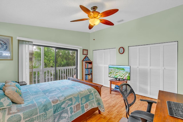 bedroom with hardwood / wood-style flooring, ceiling fan, vaulted ceiling, a textured ceiling, and access to outside