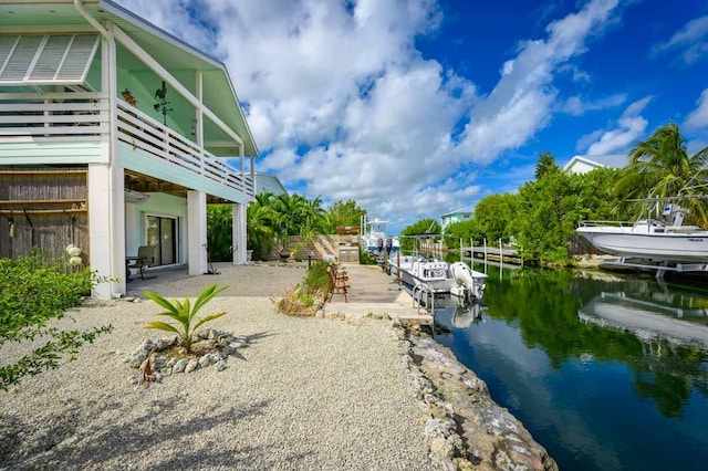 exterior space with a water view, a balcony, and a patio