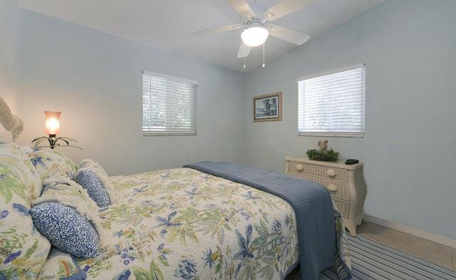 tiled bedroom featuring ceiling fan and multiple windows