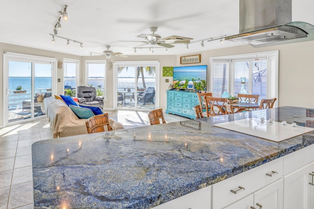 kitchen featuring extractor fan, ceiling fan, open floor plan, white cooktop, and white cabinets