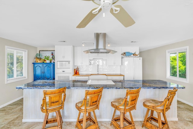 kitchen with white appliances, a wealth of natural light, backsplash, and island range hood