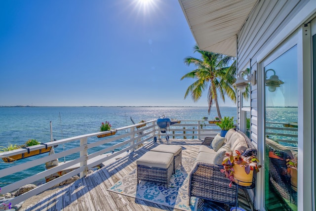 dock area with a water view and a balcony