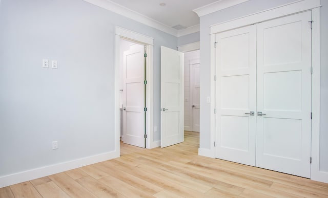 unfurnished bedroom featuring a closet, ornamental molding, and light hardwood / wood-style floors