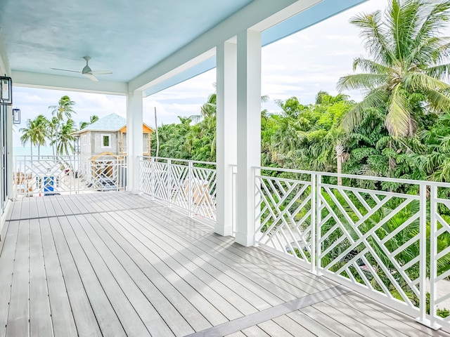 wooden deck featuring a water view and ceiling fan