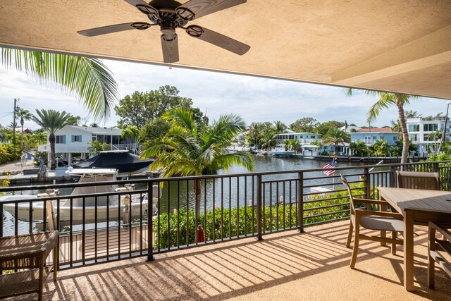 balcony featuring a grill, ceiling fan, and a water view