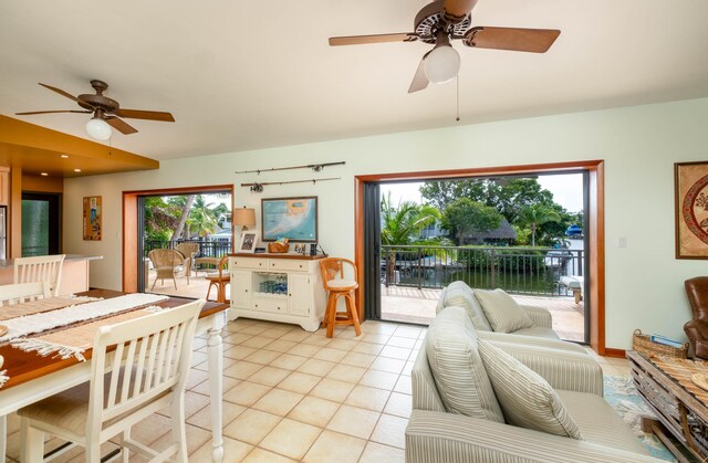 tiled living room featuring a water view and ceiling fan