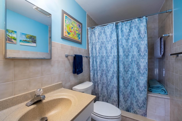 bathroom featuring vanity, toilet, a shower with shower curtain, and tile walls