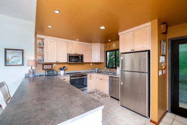 kitchen featuring sink, light tile patterned floors, stainless steel appliances, kitchen peninsula, and light brown cabinets