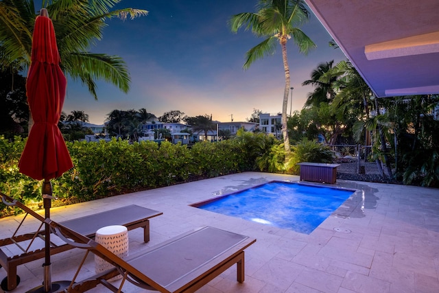 pool at dusk featuring a patio area