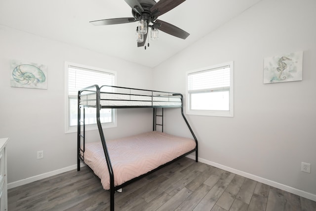 unfurnished bedroom with multiple windows, lofted ceiling, dark hardwood / wood-style floors, and ceiling fan