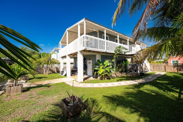 back of property featuring a deck and a lawn