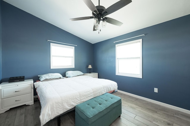 bedroom with multiple windows, vaulted ceiling, light hardwood / wood-style floors, and ceiling fan