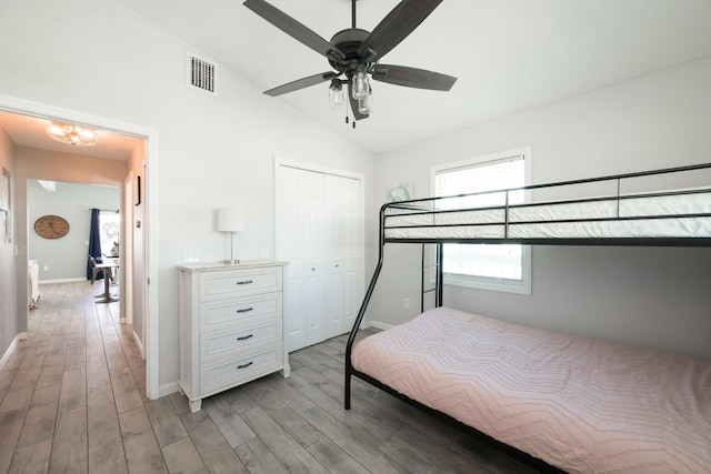 bedroom featuring lofted ceiling, a closet, ceiling fan, and light wood-type flooring