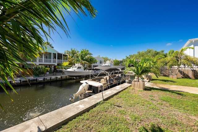 view of dock with a water view and a yard