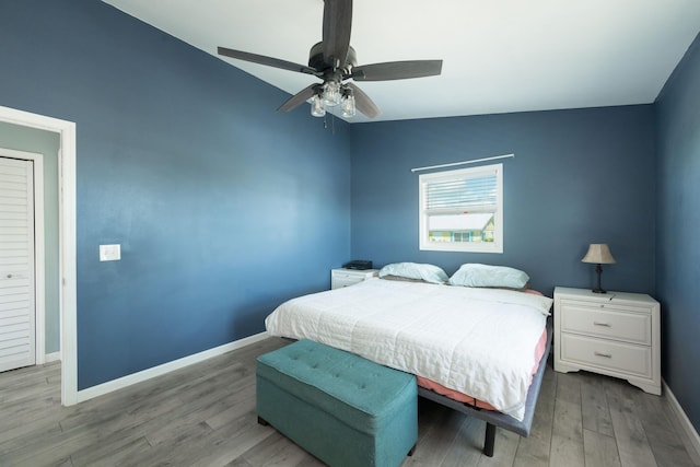 bedroom with vaulted ceiling, light hardwood / wood-style floors, and ceiling fan