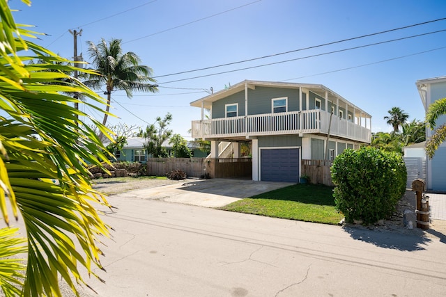 view of front of home featuring a garage, a front yard, and a balcony