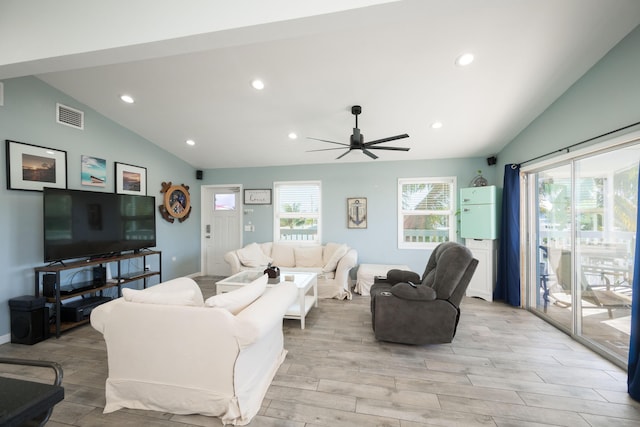 living room with lofted ceiling, a wealth of natural light, and light hardwood / wood-style flooring