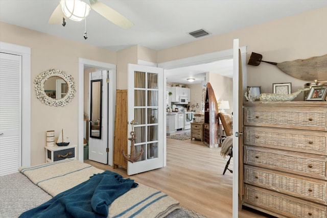 bedroom with light wood-style flooring, ceiling fan, and visible vents