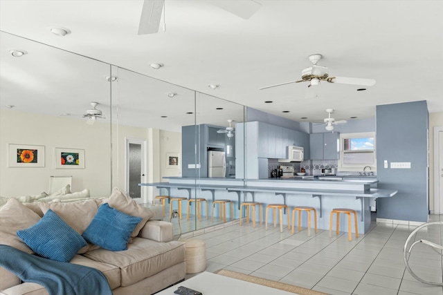 living room with ceiling fan and light tile patterned floors