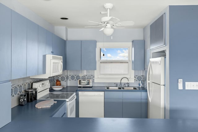 kitchen featuring blue cabinets, sink, backsplash, and white appliances