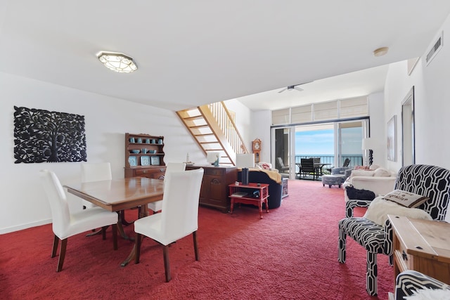 dining room featuring carpet, visible vents, stairway, and baseboards