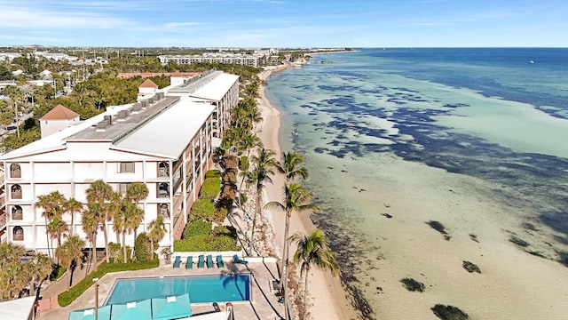 birds eye view of property with a water view and a beach view