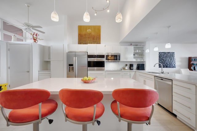 kitchen featuring stainless steel appliances, open shelves, a sink, and light countertops