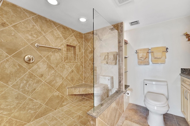 bathroom featuring tile patterned floors, vanity, toilet, and walk in shower