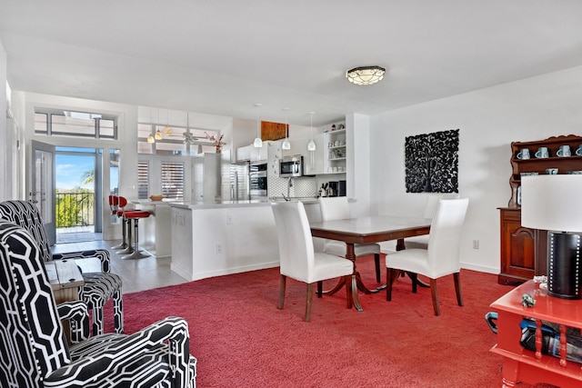 dining space featuring carpet and baseboards