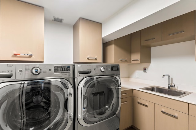 laundry room with washer and dryer, visible vents, a sink, and cabinet space