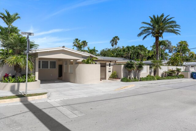 view of front of house with a fenced front yard, concrete driveway, and stucco siding