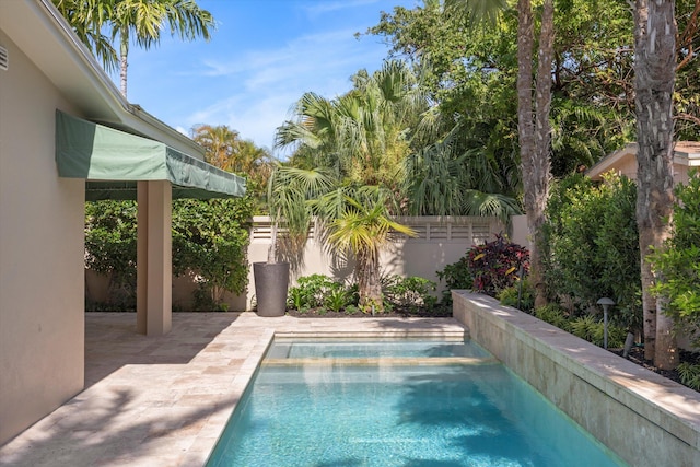 view of pool featuring a patio area, a fenced backyard, and a pool with connected hot tub