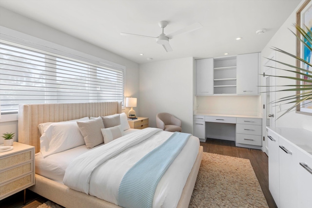 bedroom featuring a ceiling fan, recessed lighting, dark wood finished floors, and built in desk