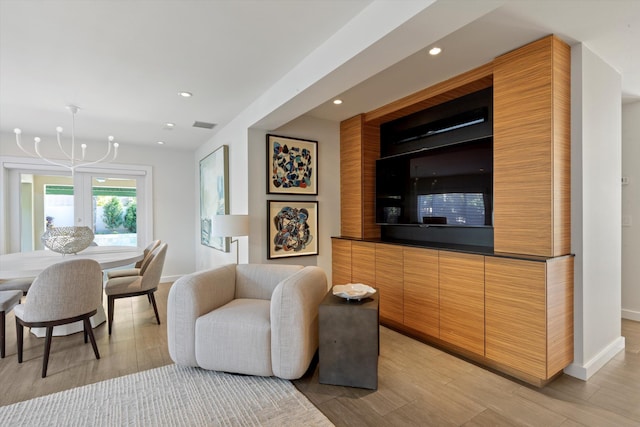 living room featuring recessed lighting, baseboards, light wood finished floors, and an inviting chandelier