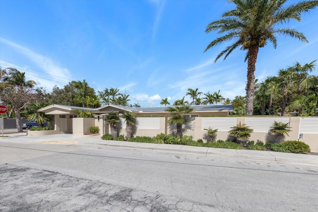 mid-century modern home featuring a fenced front yard and driveway