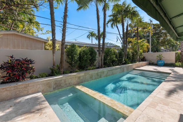 view of swimming pool featuring an in ground hot tub, a patio area, and a fenced backyard