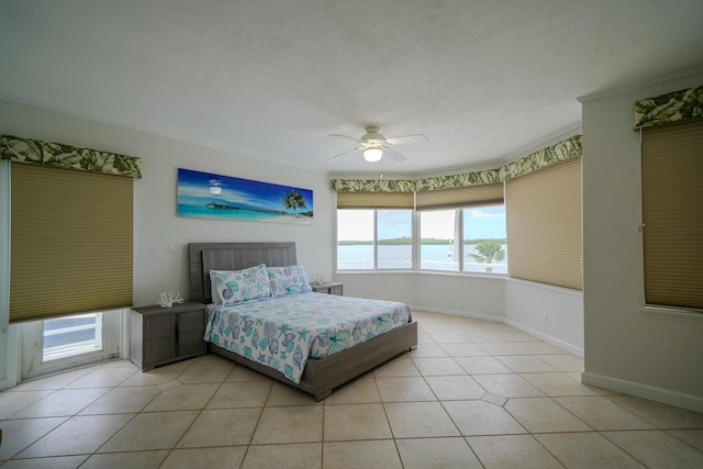 tiled bedroom with ceiling fan and a water view