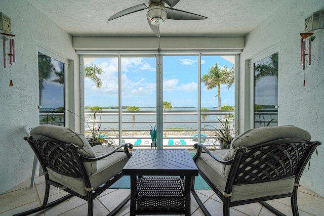 sunroom / solarium with a water view, a wealth of natural light, and ceiling fan