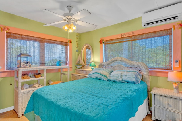 bedroom with ceiling fan and a wall unit AC