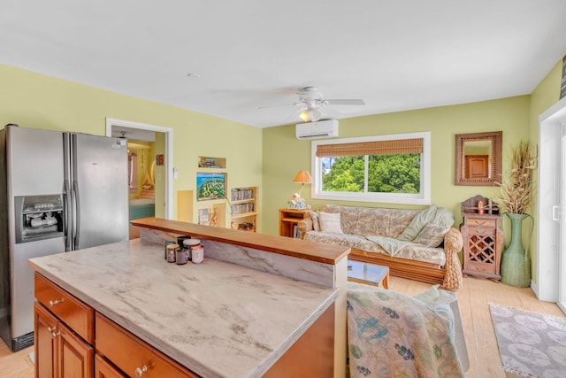 kitchen with a center island, a wall mounted AC, stainless steel fridge, ceiling fan, and light hardwood / wood-style floors