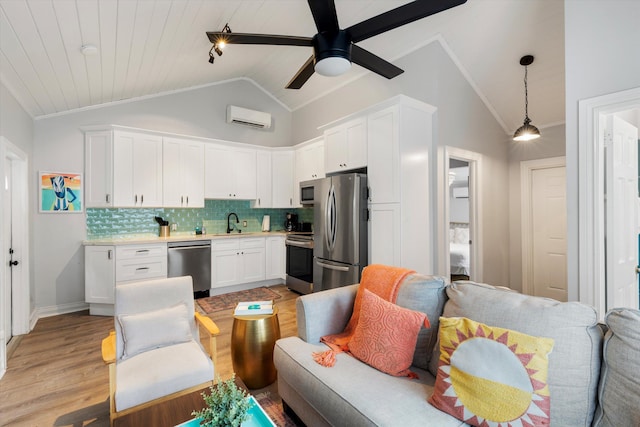 kitchen with appliances with stainless steel finishes, white cabinetry, hanging light fixtures, a wall mounted AC, and vaulted ceiling