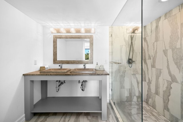 full bathroom featuring a marble finish shower and a sink