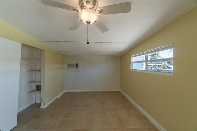 empty room featuring baseboards, an AC wall unit, ceiling fan, and vaulted ceiling