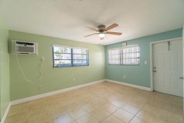 empty room featuring light tile patterned floors, baseboards, ceiling fan, and a wall mounted AC