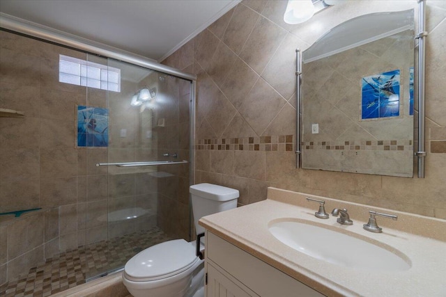 bathroom with a shower stall, tile walls, toilet, ornamental molding, and vanity