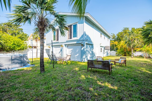 view of yard featuring a garage, a fenced in pool, and fence