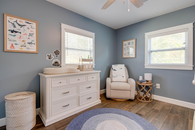 sitting room with baseboards, dark wood finished floors, and a ceiling fan